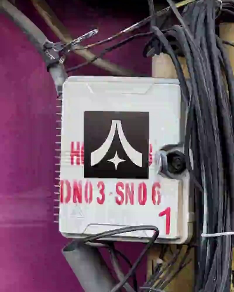 The Asa Studio mark on a street junction box among tangled cables