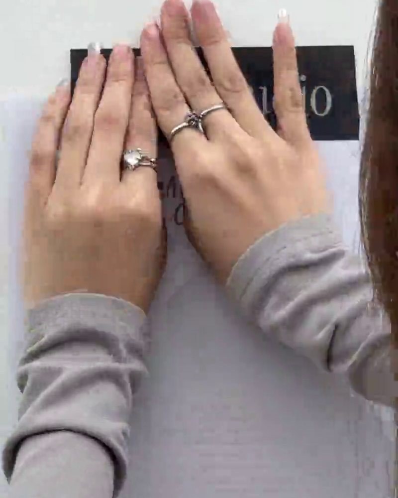 Hands smoothing an Asa Studio launch poster onto a wall