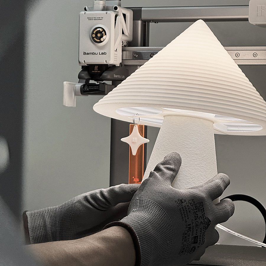A member of the Asa Studio team hand-fitting an engraved charm to a NOLA lamp